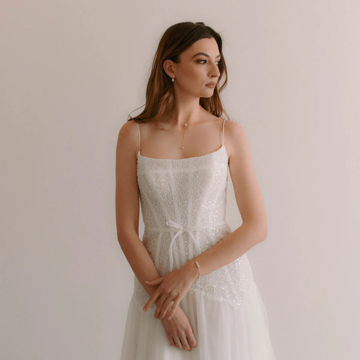 A French Chic Bride wearing pearl necklace, earrings and bracelet in gold metal.