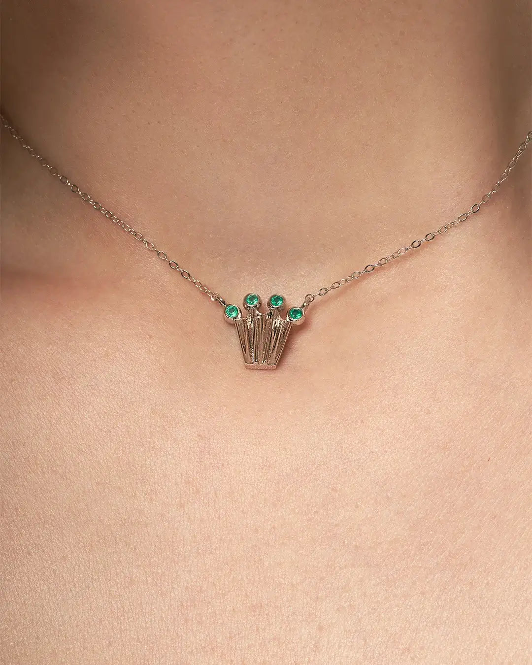 Silver chain necklace with a crown form pendant with green onyx gemstones