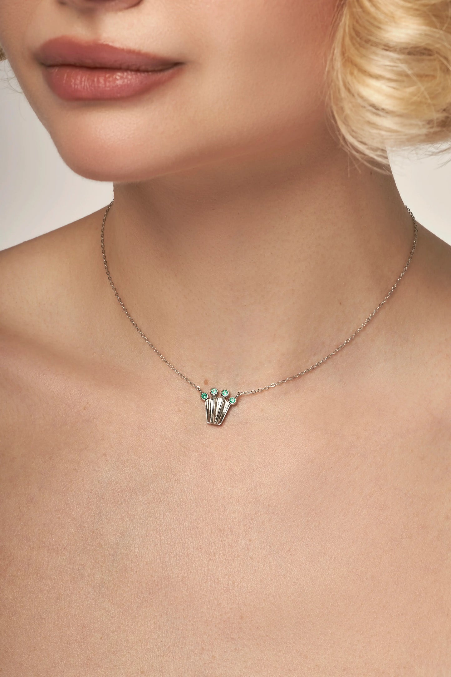 Silver chain necklace with a crown form pendant with green onyx gemstones