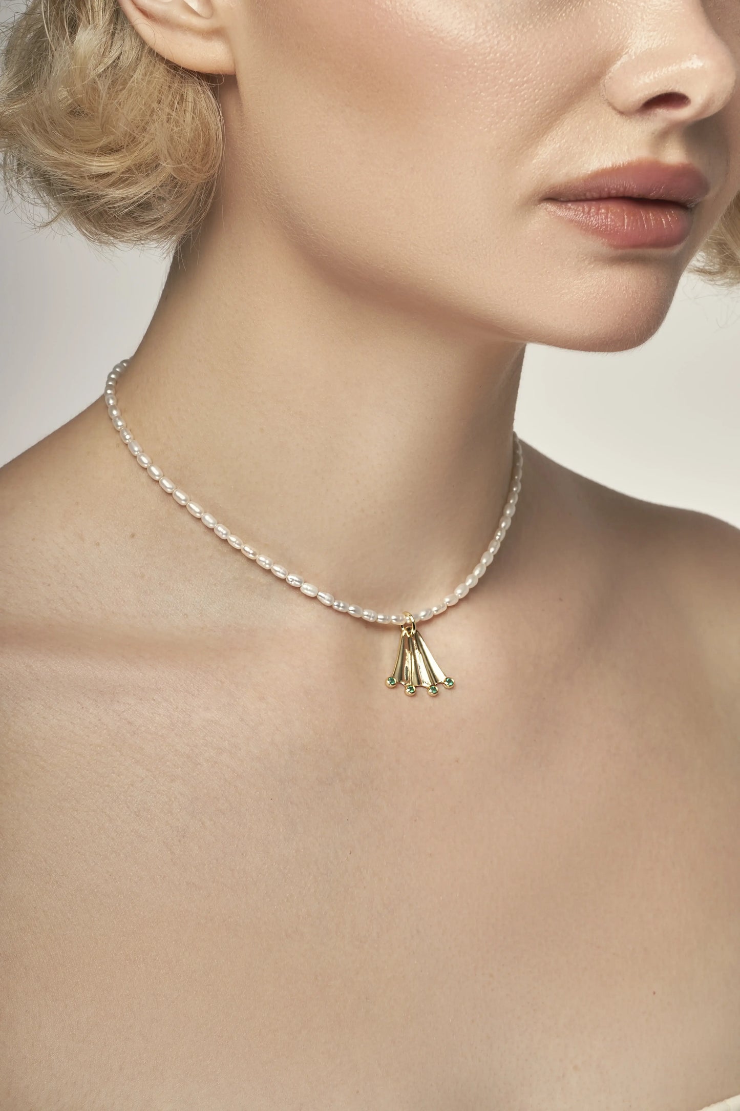 Rice white pearl necklace with a gold Frog paw-shaped pendant with green onyx gemstones