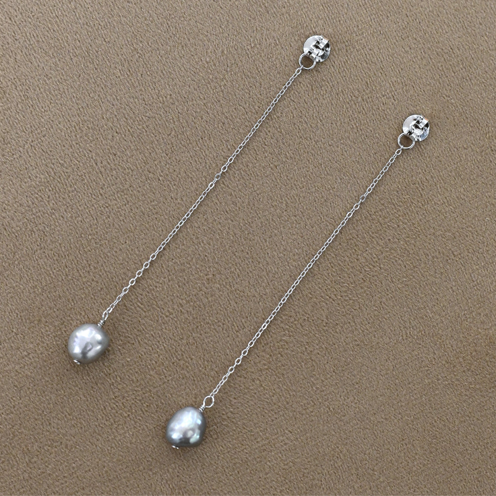 
                      
                        Silver drop and chain earrings with grey baroque pearls
                      
                    