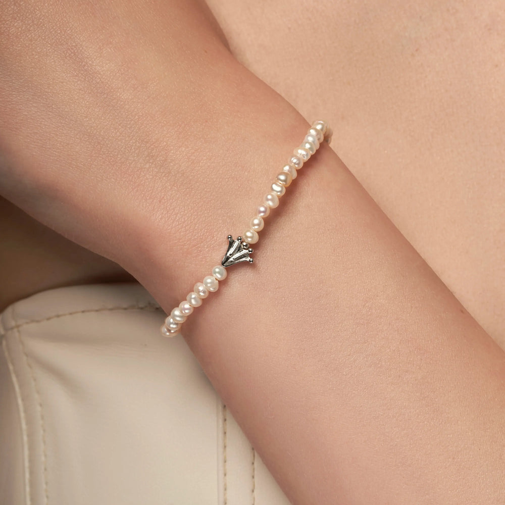 Bracelet with small white pearls and a frog's paw charm