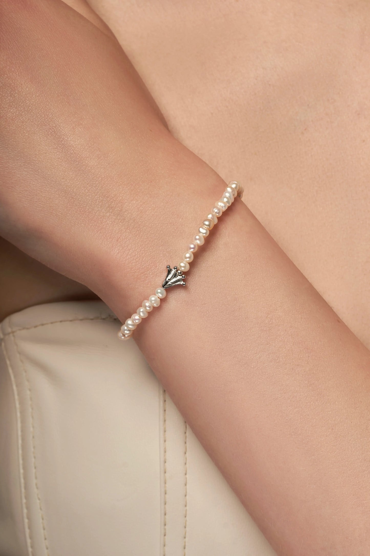 Bracelet with small white pearls and a frog's paw charm
