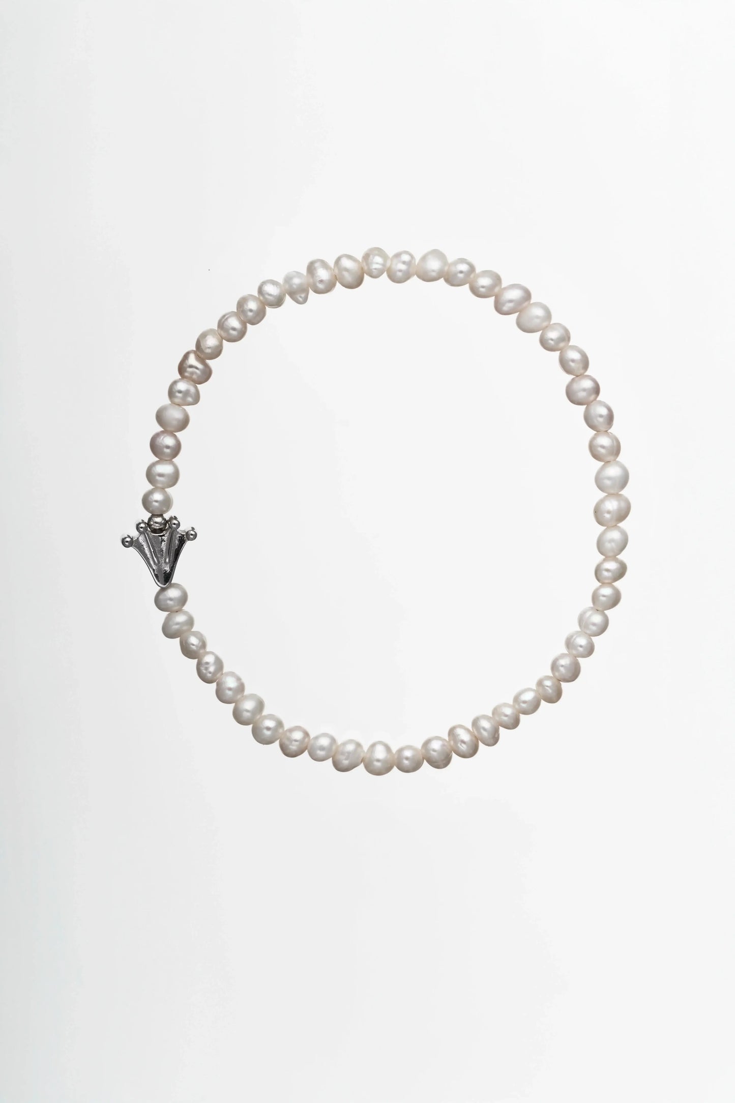 Bracelet with small white pearls and a frog's paw charm