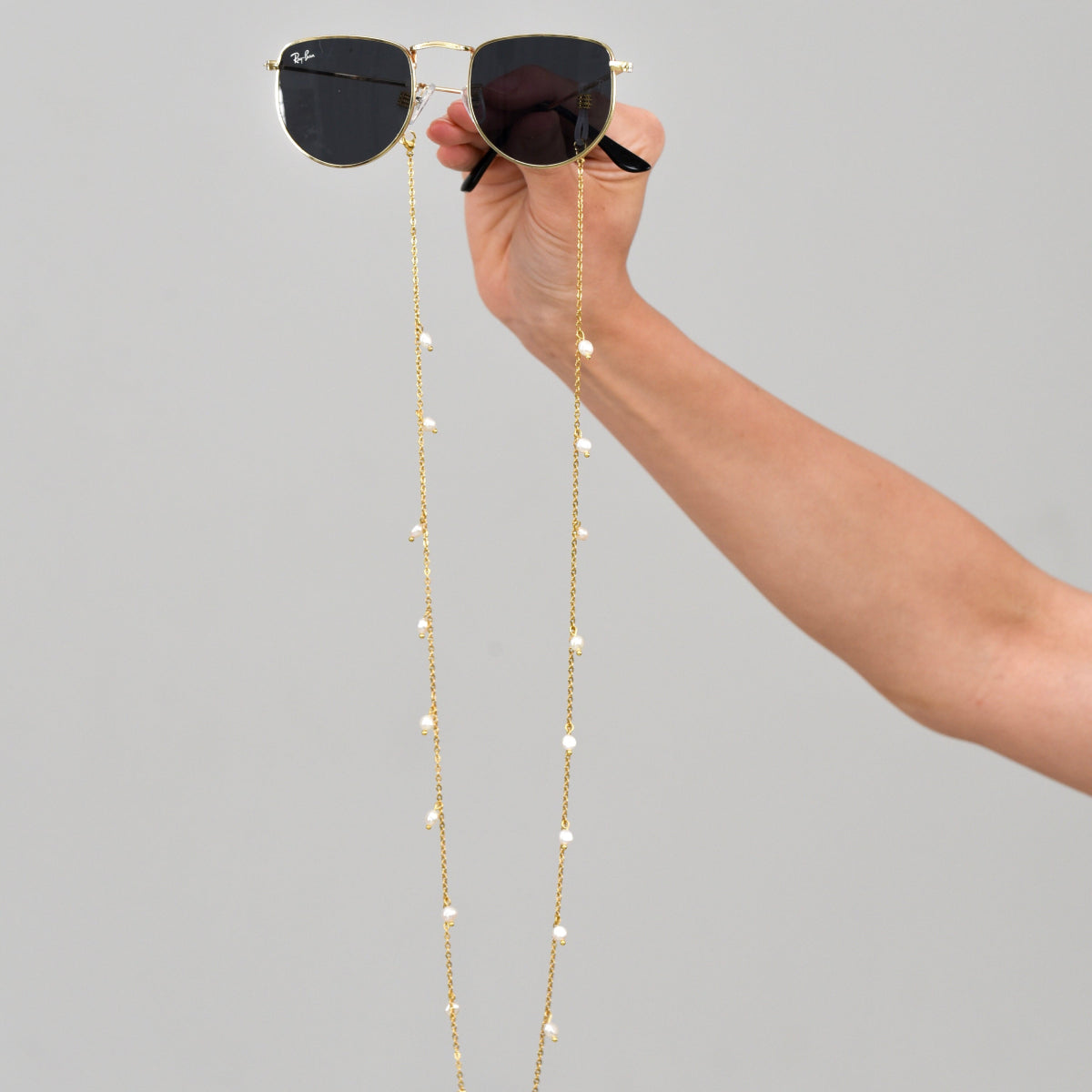 Sunglasses with a gold chain and baroque pearls