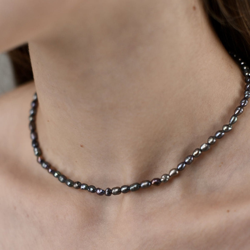 
                      
                        Choker with 4 mm black baroque pearl in rhodium-plated silver worn around the neck.
                      
                    